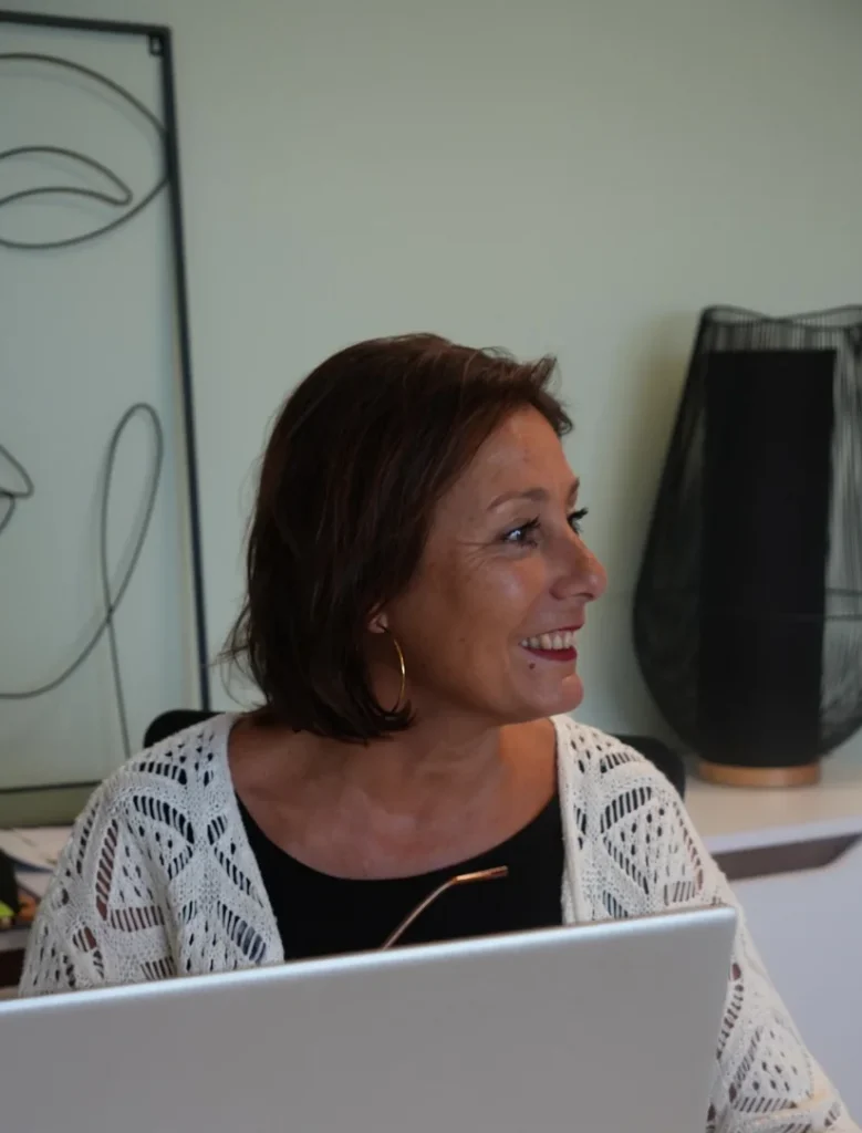 Delphine Girard, courtière DGI Courtage, souriante à son bureau